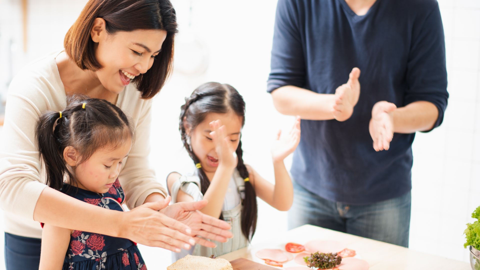 一家人在厨房里一起做三明治。