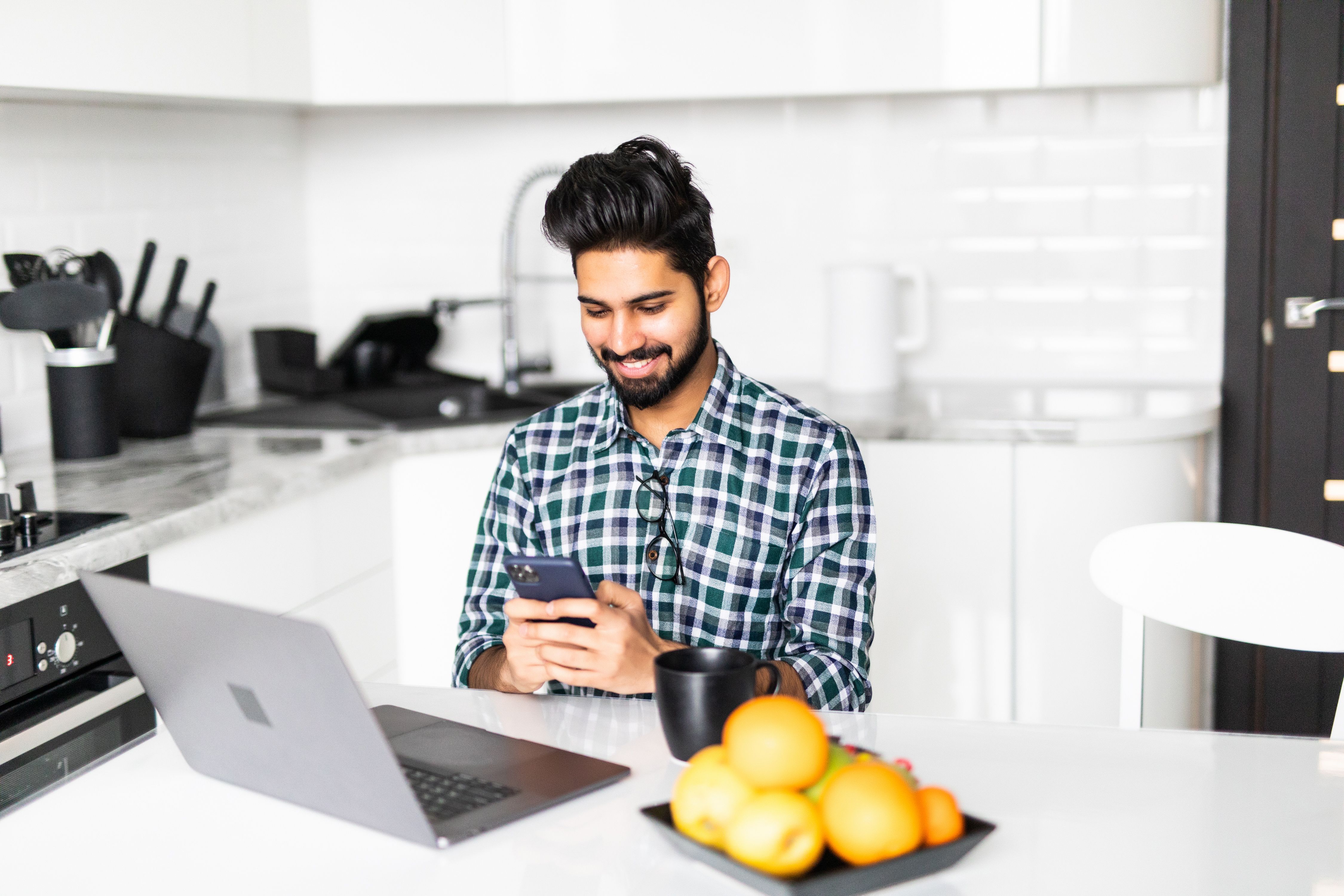 拿着手机和笔记本电脑的男人